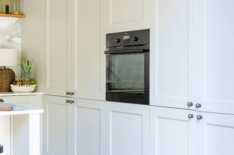 Tall run of cabinetry with a pantry and oven.