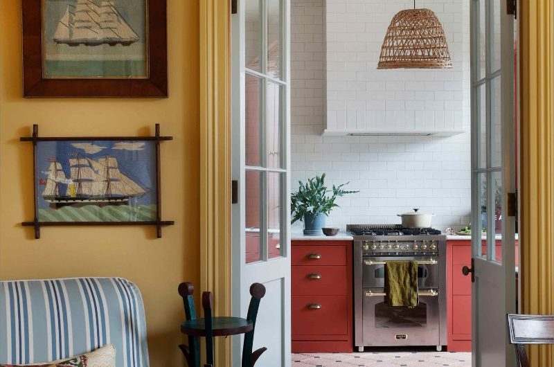 Living room looking into the kitchen with art on the walls and striped soft furnishings.