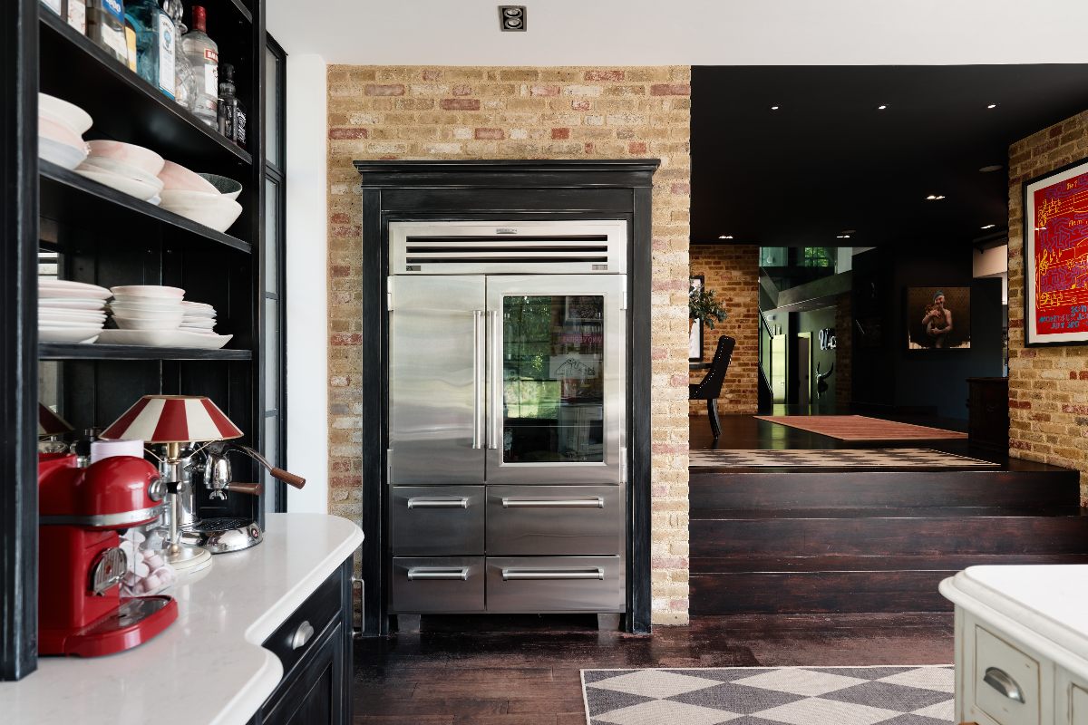 A closeup at the stainless steel fridge-freezer which sits close to the cooking zone.