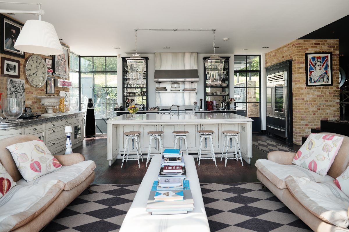 A kitchen design with stainless steel appliances on show, a large island, exposed brick walls and industrial decor.
