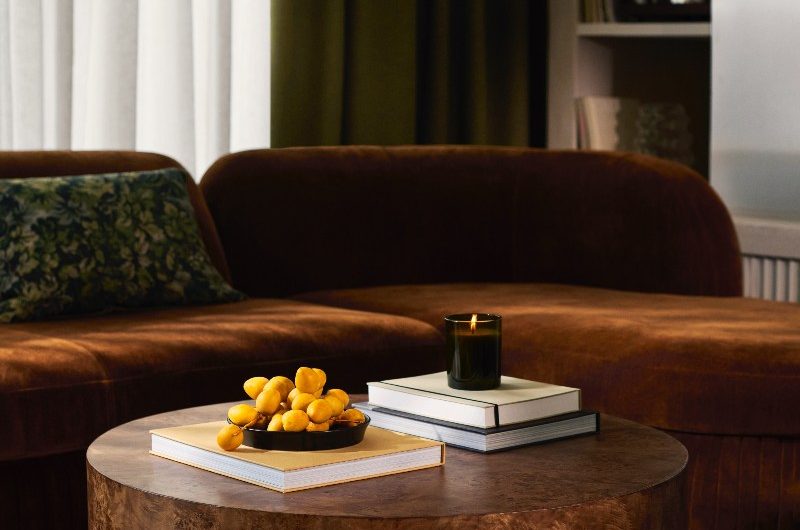 Closeup at an autumn snug area with a brown sofa and stone coffee table.