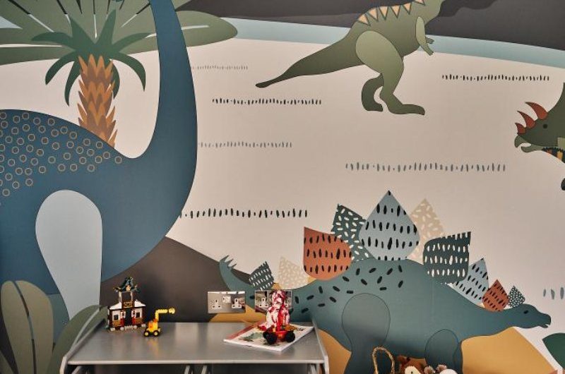 Jurassic-inspired mural in a kids' bedroom.