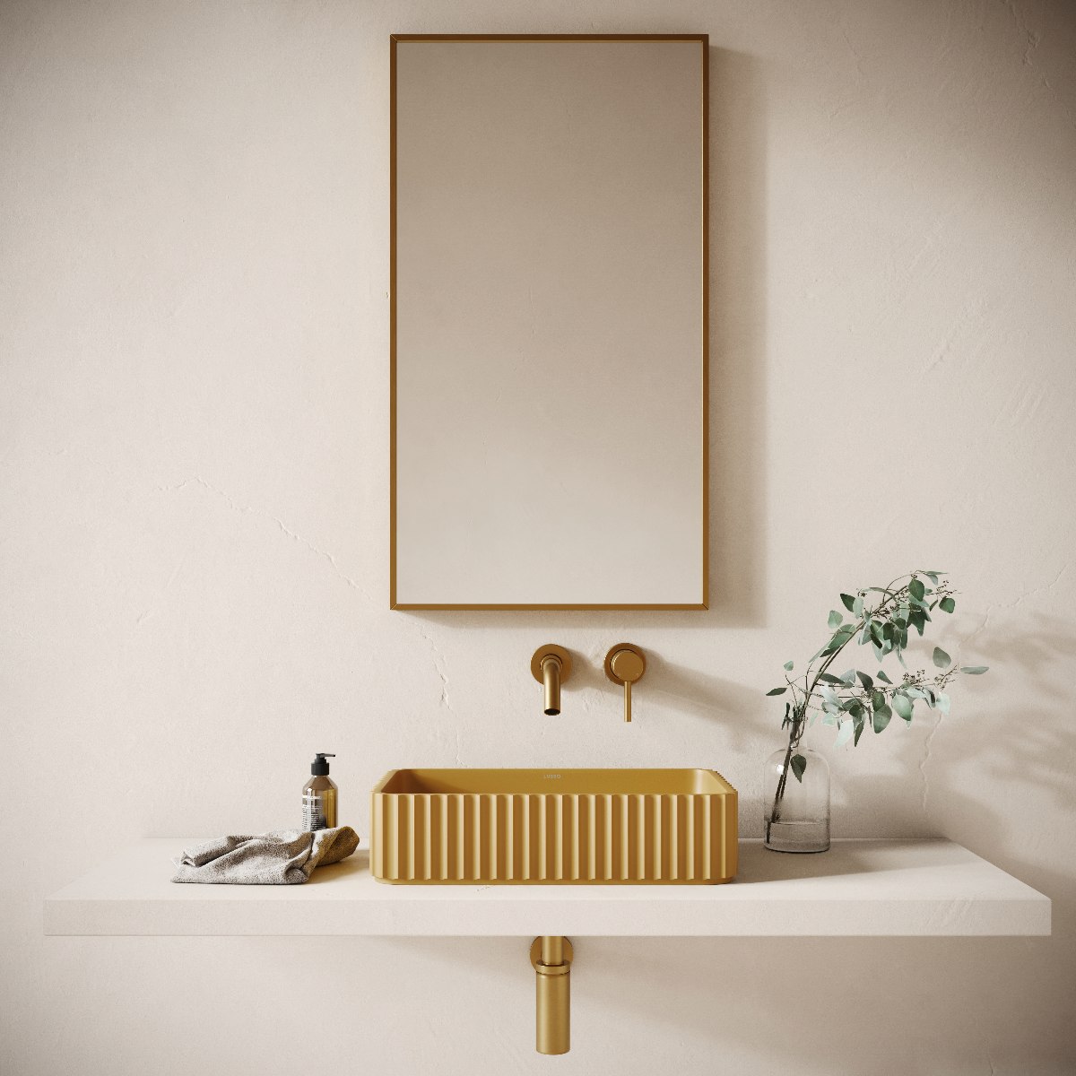 A neutral space with a mustard basin embellished with fluting, gold brassware and a mirror above it.