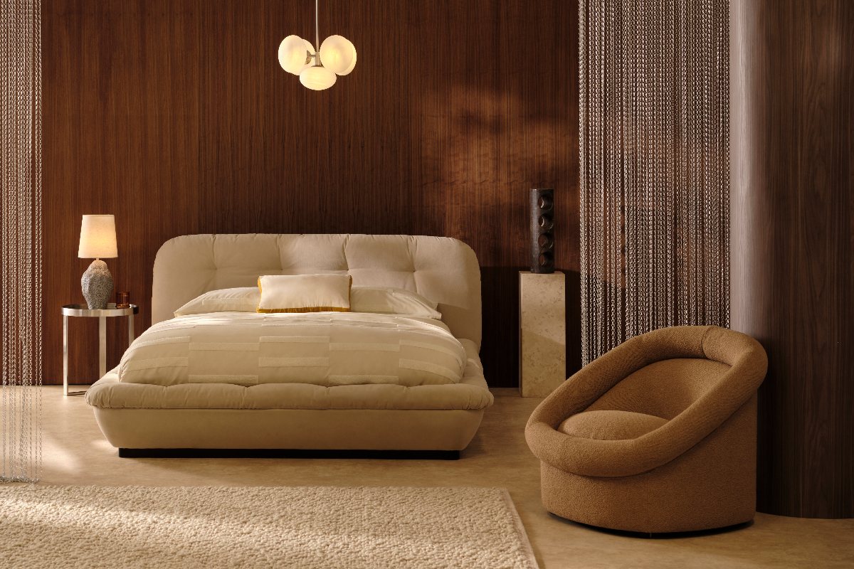 Retro bedroom with wood panelling, plush bed and accent chair, and statement lighting.