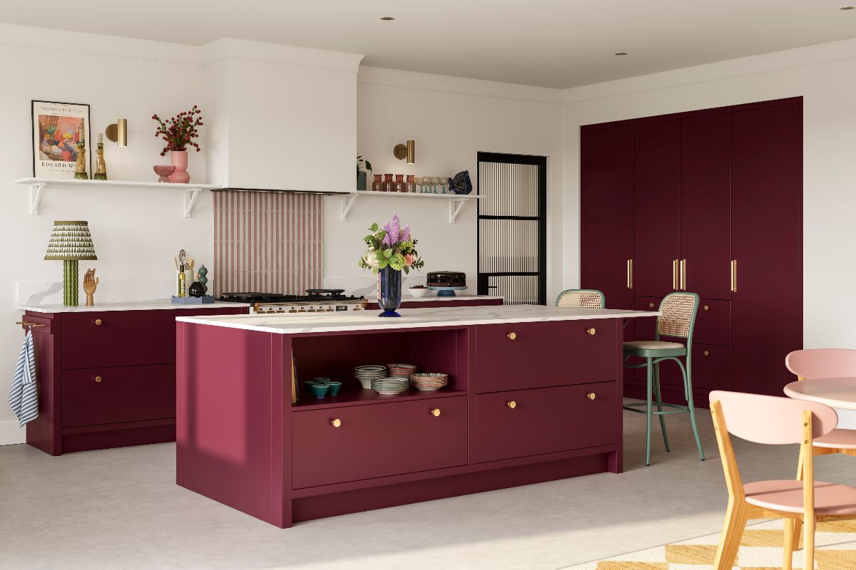 Burgundy kitchen design with a central island with storage, striped tile splashback and a range cooker.