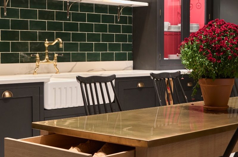Shaker cabinetry with green tiles, veiny worktop and a matching open shelf.