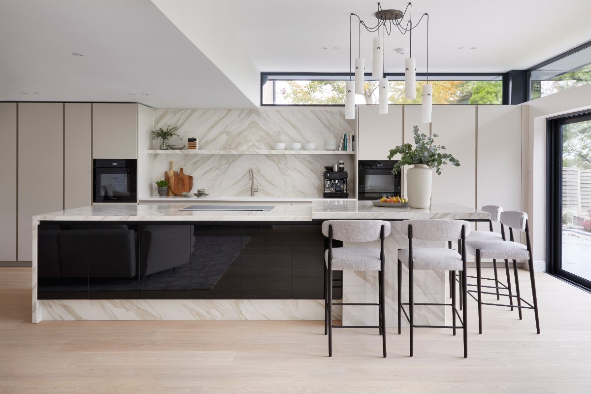 Luxury kitchen design with a statement island with seating and marbled surfaces.