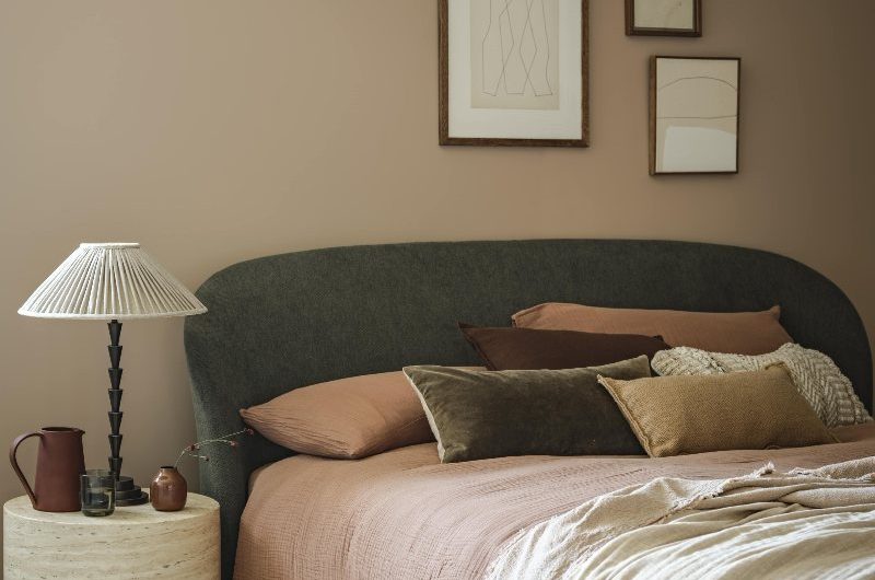 Mid-century-inspired bedroom with sleek and sophisticated furniture, stone pieces, and muted pastel linen.