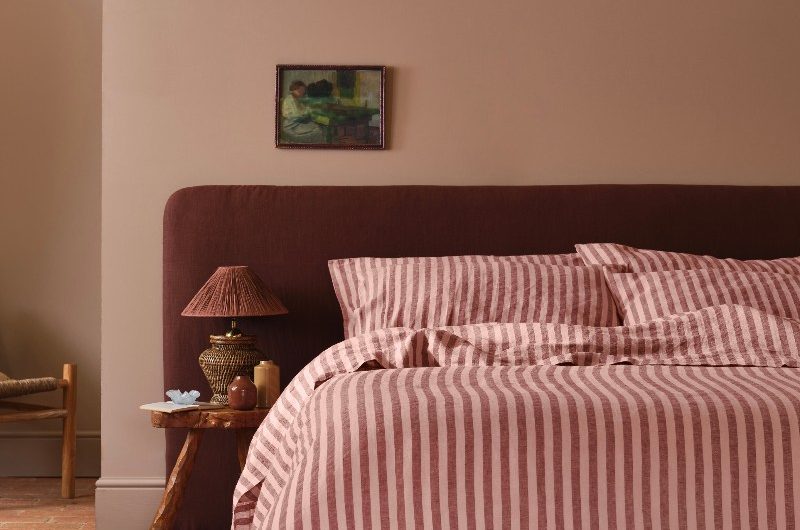 Bedroom design with striped bedding and natural materials.
