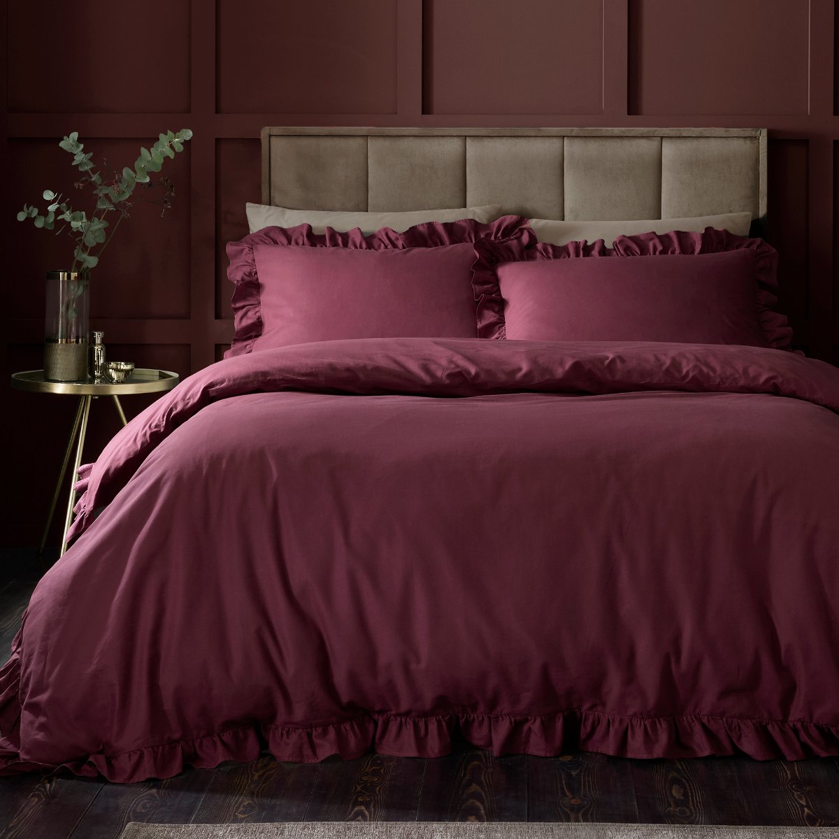 Moody scheme with classic wall panelling, a velvet bed and jewel tone linen.