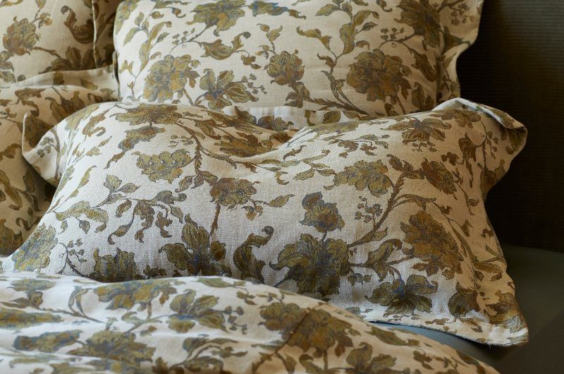 Autumn Winter 2025 floral bedding with a green headboard.