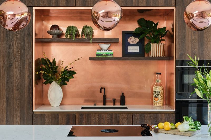 A closeup at the sink zone with copper splashback.