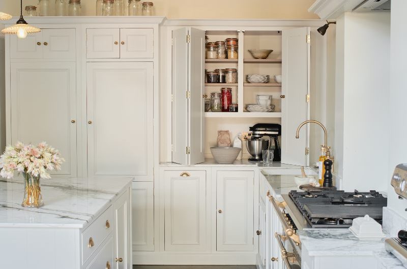 L-shaped cabinetry painted in white with statement appliances and timeless surfaces.