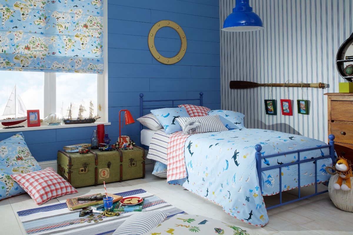 Nautical bedroom with striped wallpaper, shiplap panelling, wood flooring, and blue furnishings.