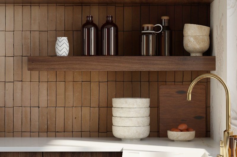 U-shaped kitchen with terracotta tiles, white worktops, wood shelves and a sink and tap area.