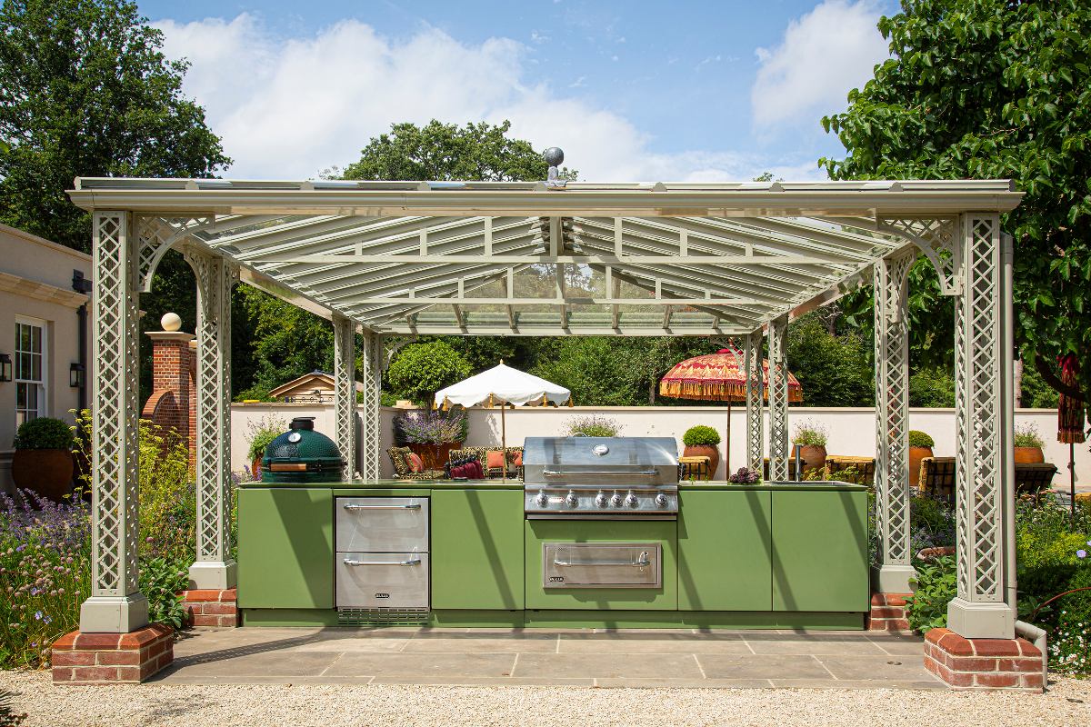 Colourful outdoor kitchen with a barbecue, oven and Kamado Joe grill.
