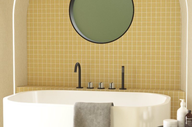 Yellow bathroom with an arched showering bath zone, a freestanding tub, black brassware, and LED lighting.