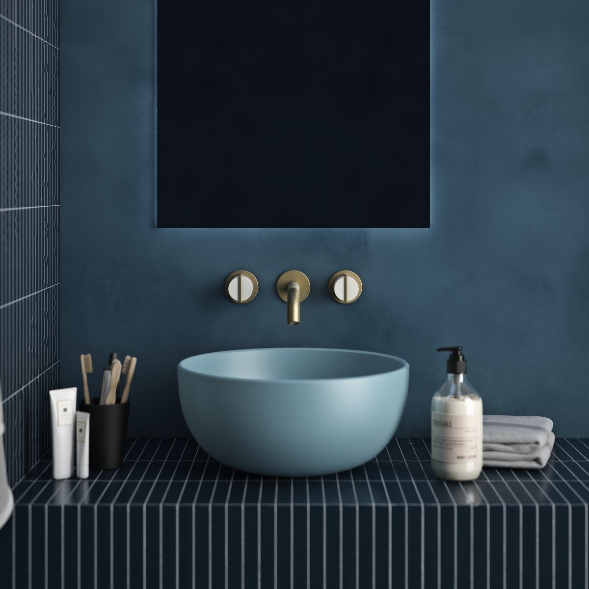 A blue bathroom with blue basin, gold brassware and lit-up mirror.