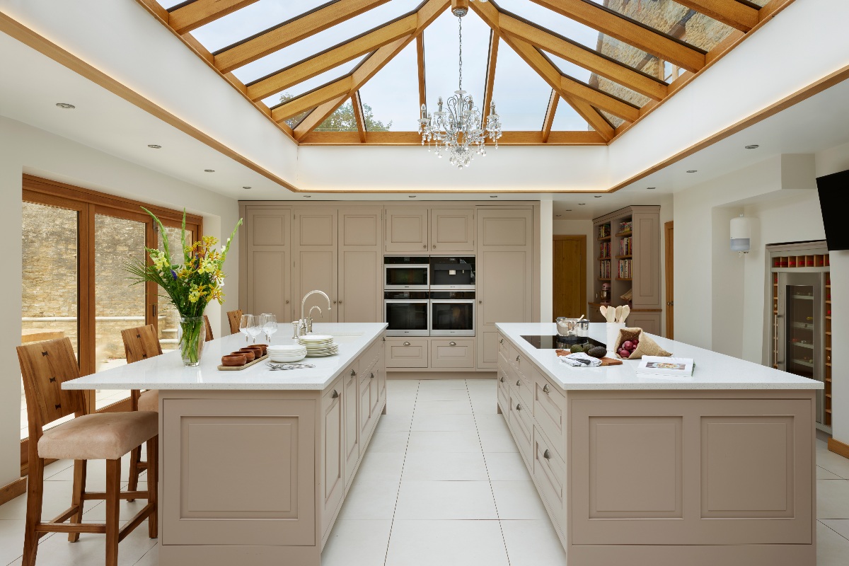 Neutral cabinetry with double island and a grand roof lantern. 