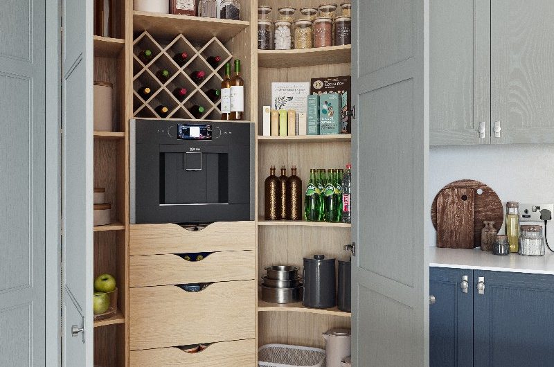 A blue kitchen design with a spacious walk-in pantry with a coffee machine, shelves and drawers.
