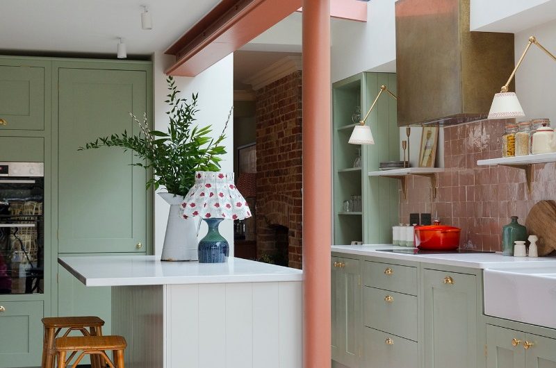Classic Shaker kitchen with gold hardware, a painted structural beam, a concealed extractor and narrow skylight. 