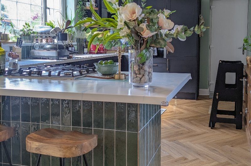 A kitchen renovation with herringbone flooring, a tiled island, and stainless steel appliances.