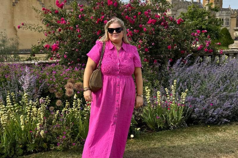 A homeowner in a garden with colourful flowers.