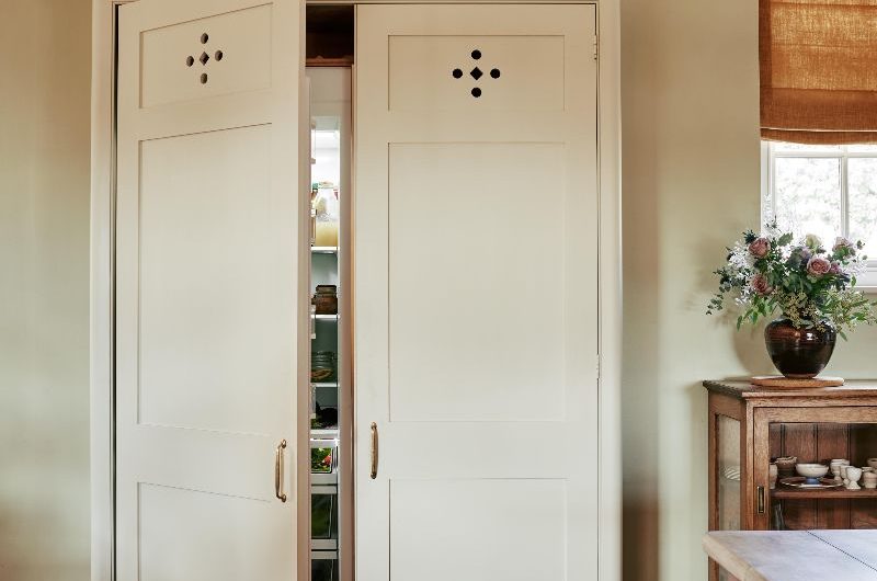 A freestanding piece of cabinetry hiding a fridge inside.