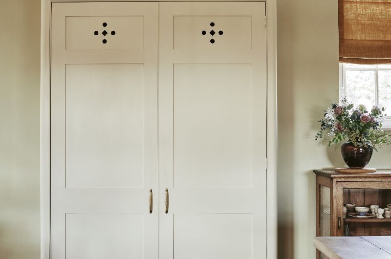 A freestanding piece of cabinetry with ventilation holes and minimalist handles.