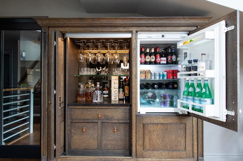 A bar area concealed in a grand piece of wood furniture.