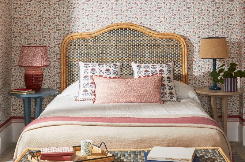 Charming bedroom design with a statement bed frame, floral wallpaper, and table lamps.