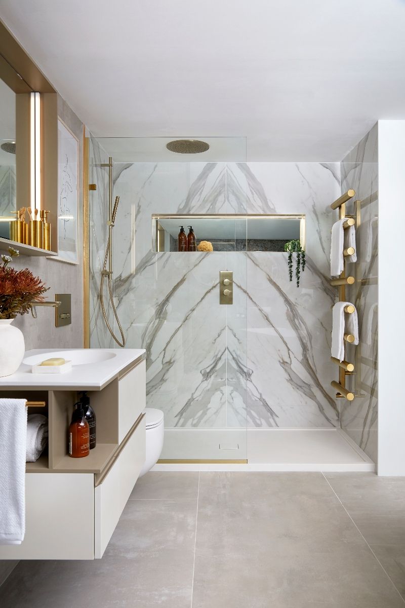 Luxury bathroom with gold finishes, marble tiles, and sleek furniture.
