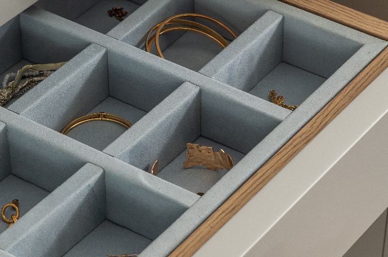 Closeup at jewellery box drawer with grey velvet interiors.