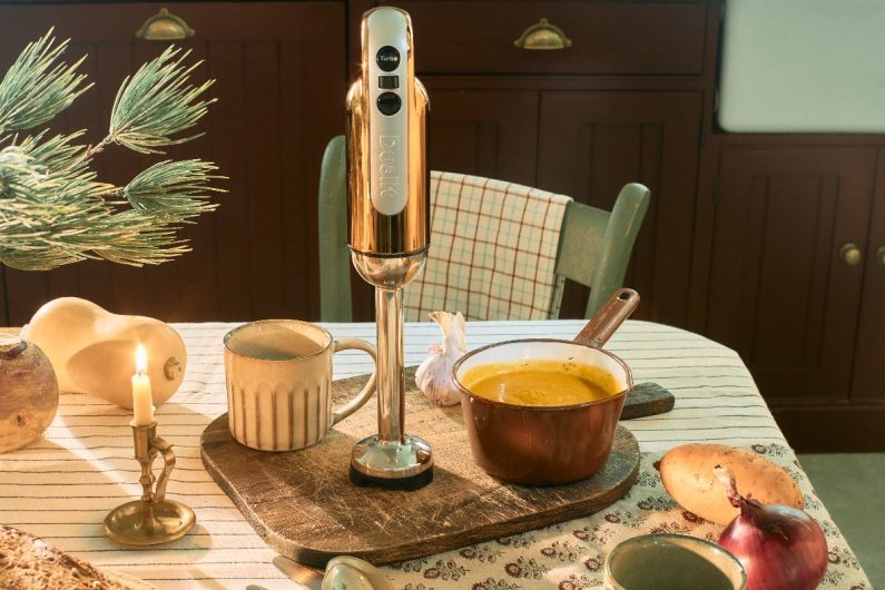 Kitchen design with a dining table, green chair, and soup making essentials.