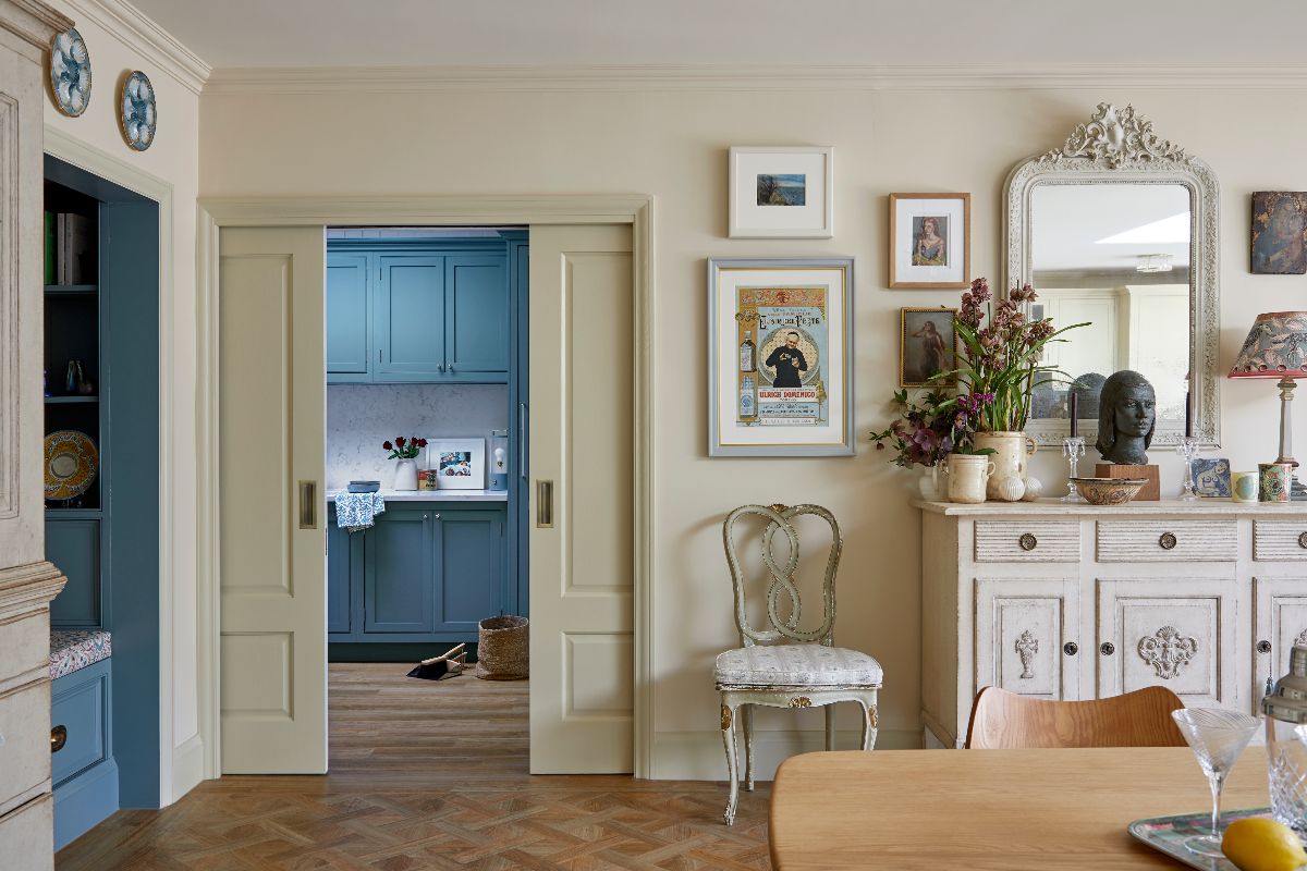 An adjoining utility room with blue cabinetry hidden behind pocket doors.