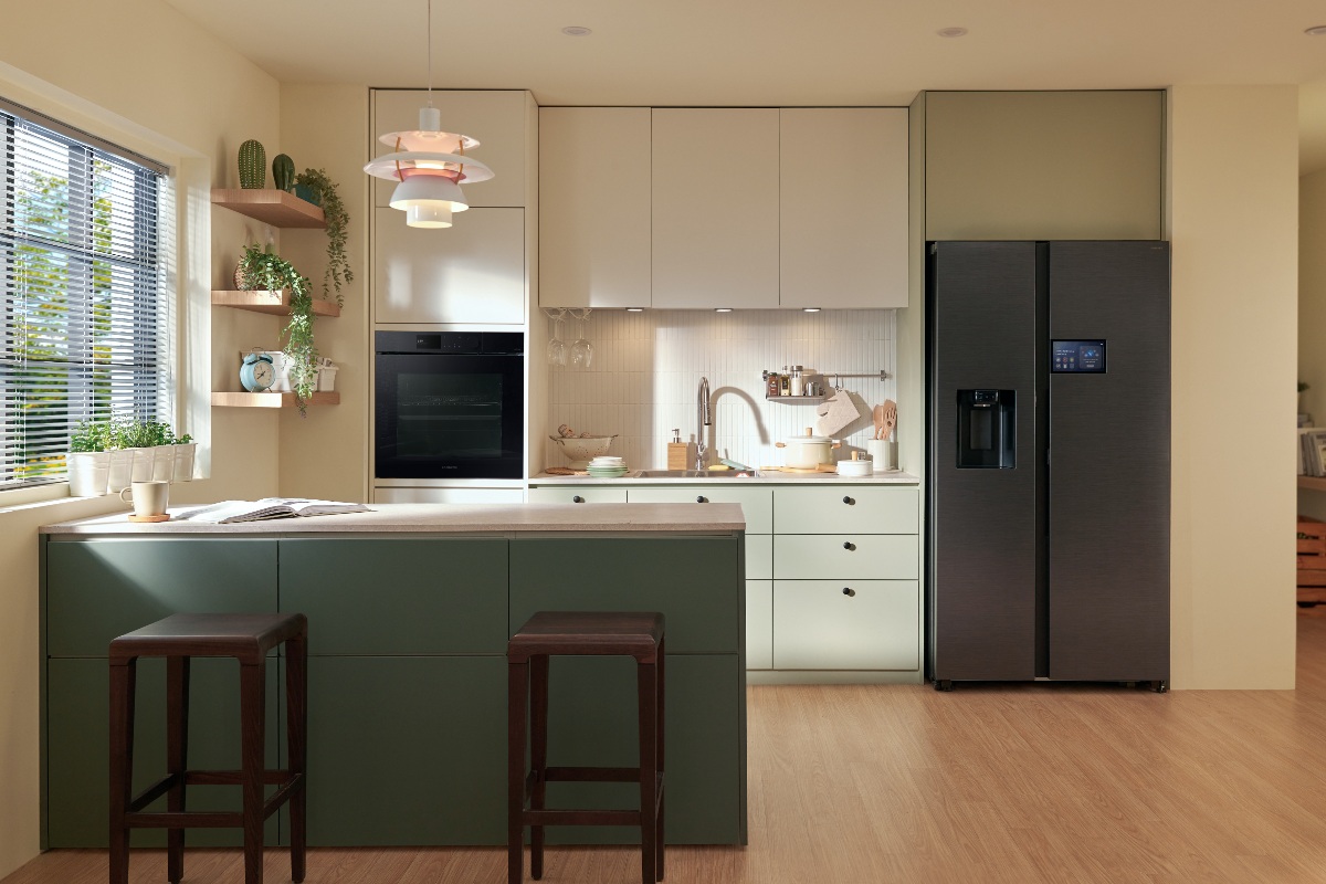Sage green cabinetry with a forest green peninsula, a double door fridge and built-in oven.