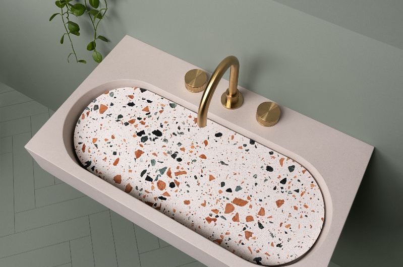 Closeup at a terrazzo basin in a green bathroom.
