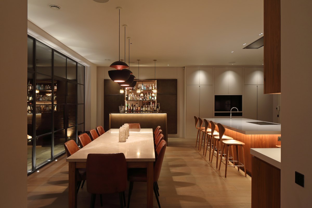 An open-plan kitchen with a combination of pendants, downlights and subtle undercounter lighting.