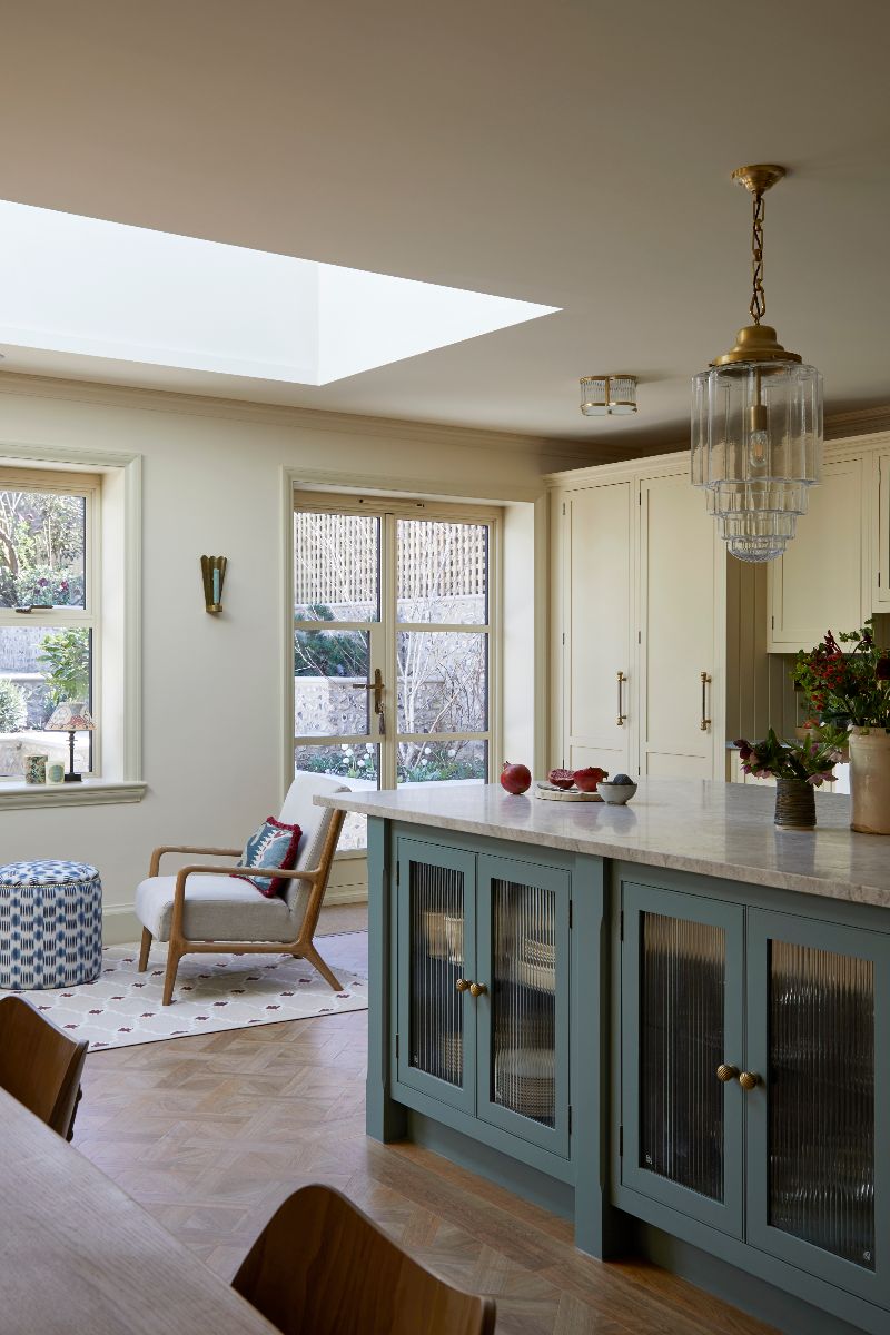 A closeup of an island with glazed units and stone worktop.