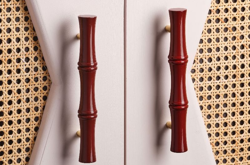 Closeup at a rattan piece of furniture with red handles.