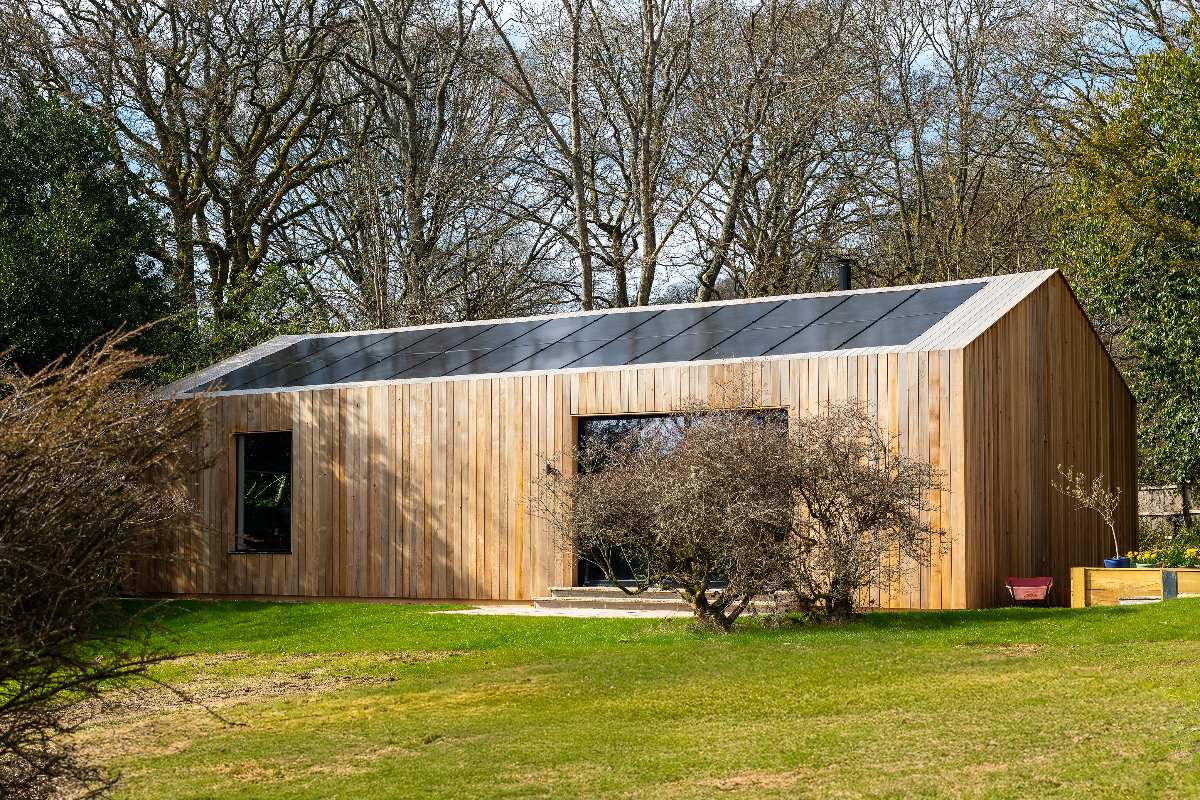 A cedar-clad barn with solar panels.