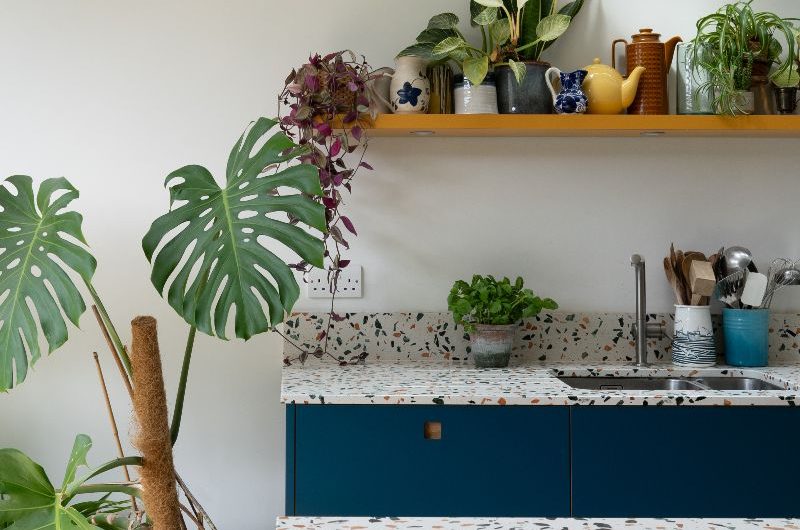 Closeup at a kitchen design with blue cabinets and speckled surfaces.
