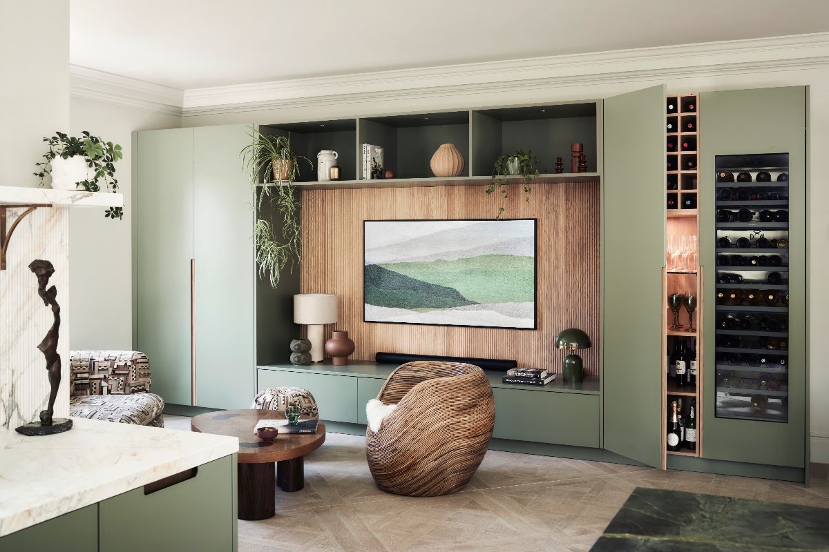 A snug with bar area, with sage and wood finishes, Japandi decor, and basket weave flooring.