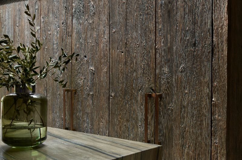 Tactile wood cabinetry in a modern space with a stone-clad island.