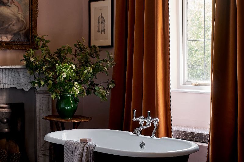Autumn bathroom with caramel curtains and a fitted tub.