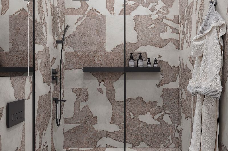 Wetroom with stone-inspired large format tiles, black brassware and storage, and white toilet.