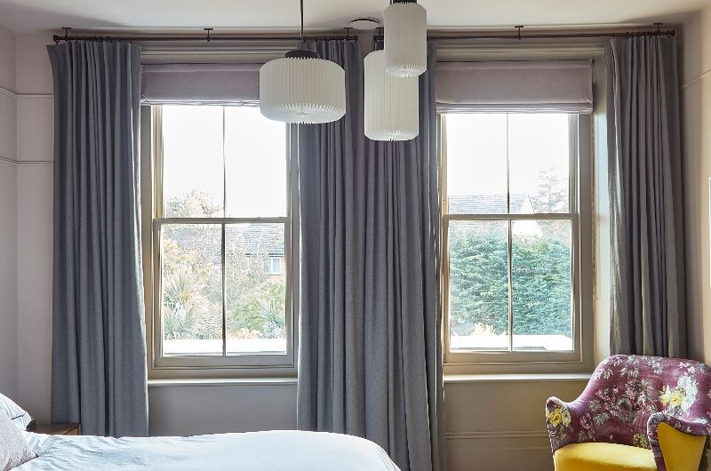 A modern bedroom design with herringbone flooring and statement ceiling.