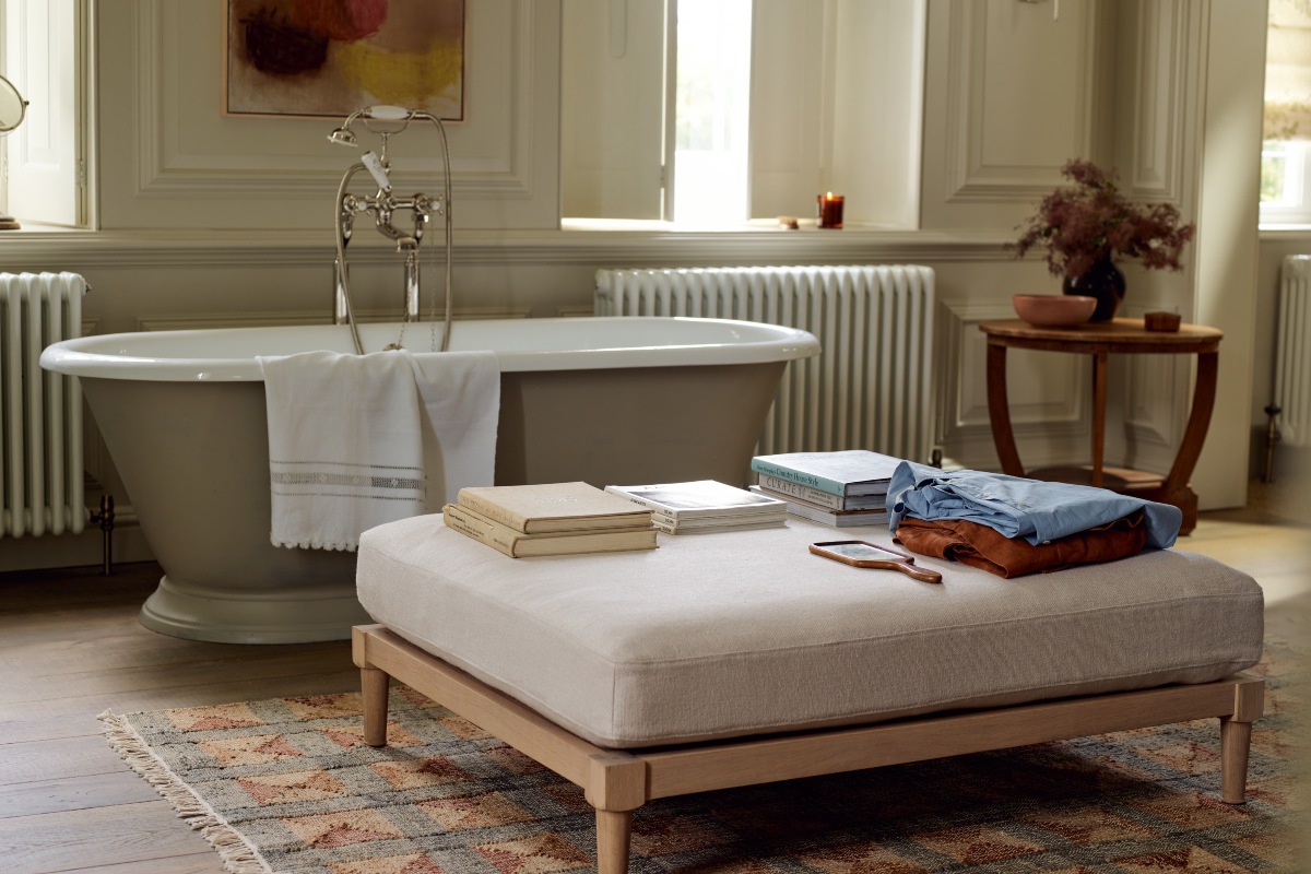 A footstool with concealed storage in a neutral bathing room.