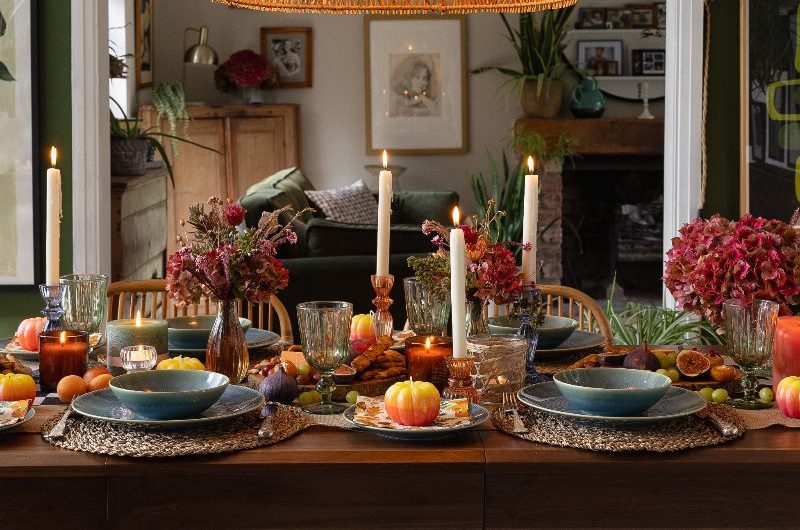 A statement setting with blue crockery, burgundy floral arrangements, charcuterie boards, and jute placemats.