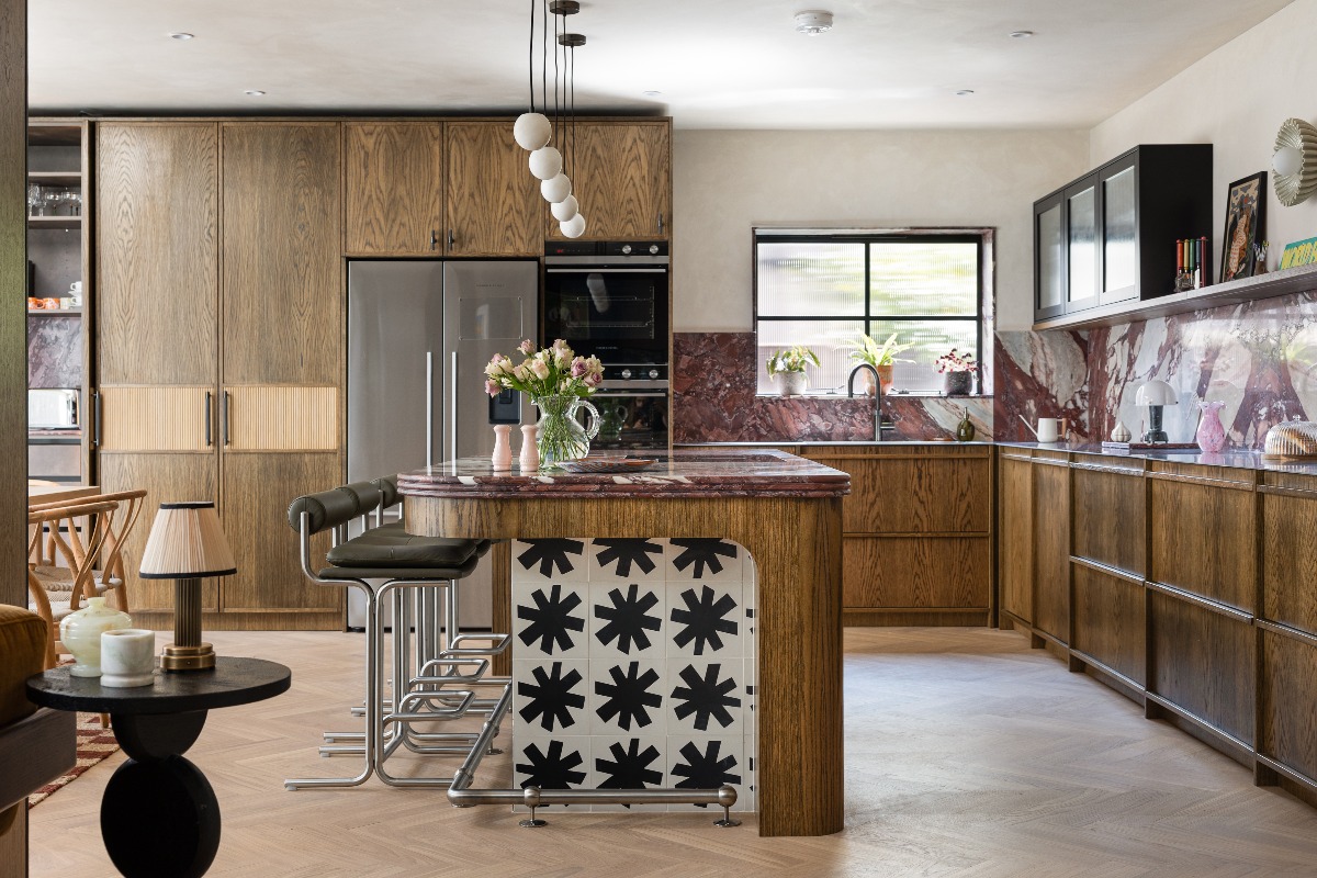 Mid century kitchen design with wood cabinetry, coloured stone, and black accents.